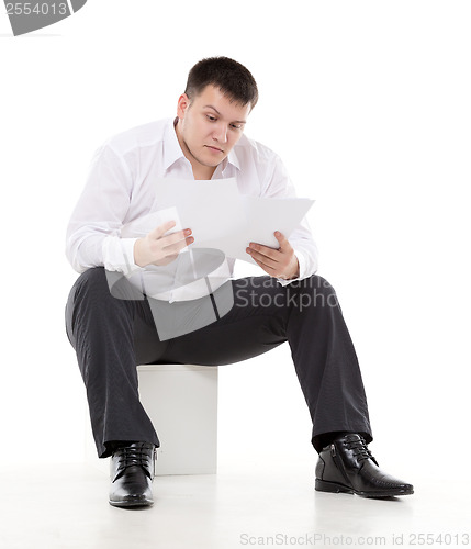 Image of Businessman reading a report with scepticism