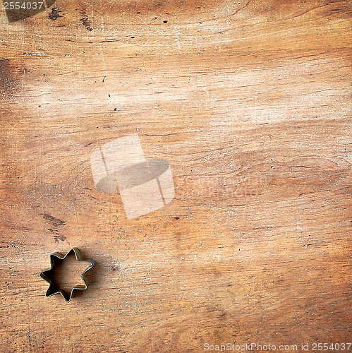 Image of pastry cutter on wooden cutting board