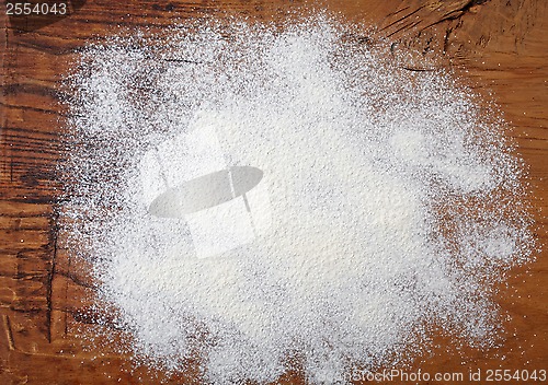 Image of white flour on wooden table