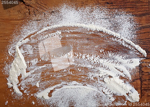 Image of white flour on wooden table