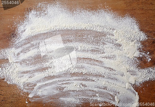 Image of white flour on wooden table