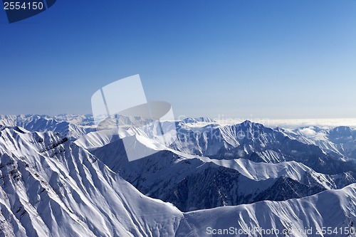 Image of Snowy rocks and blue sky in nice sun day, view from off piste sl