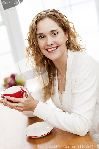 Image of Smiling woman holding red coffee cup