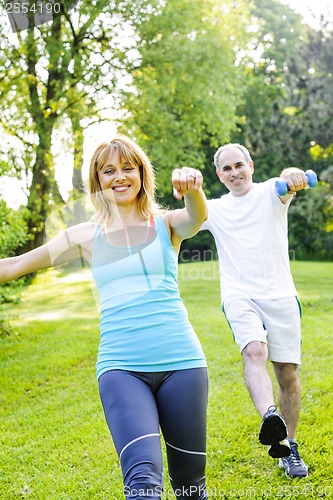 Image of Personal trainer with client exercising in park