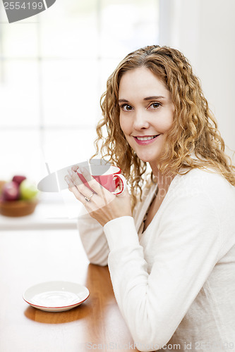 Image of Smiling woman holding red coffee cup