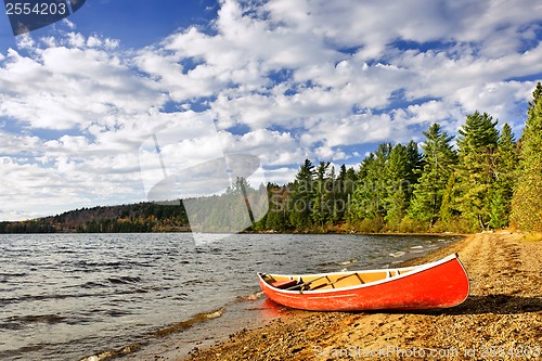 Image of Red canoe on lake shore