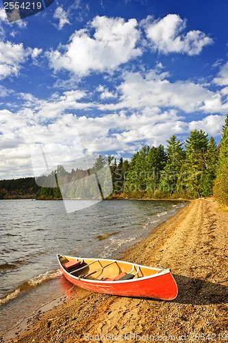 Image of Red canoe on lake shore