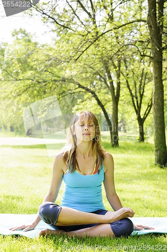 Image of Woman in lotus yoga pose outside