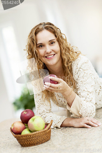 Image of Smiling woman holding apple