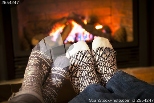 Image of Feet warming by fireplace