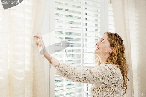 Image of Smiling woman looking out window