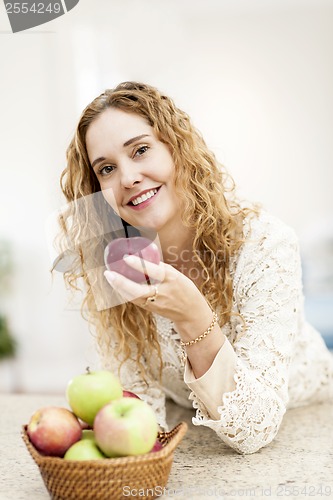 Image of Smiling woman holding apple