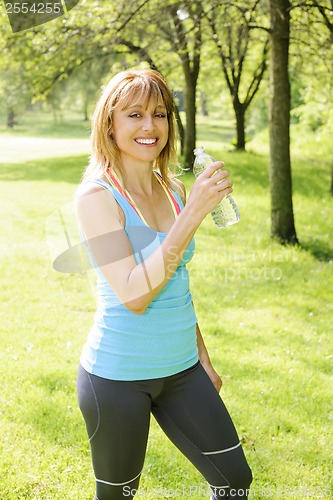 Image of Active woman holding water bottle outside