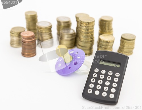 Image of pacifier with hard money and pocket calculator