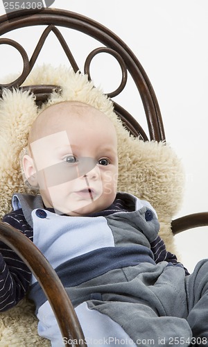 Image of newborn child in chair with sheepskin