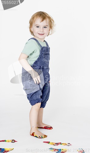 Image of child with painted feet holding trousers