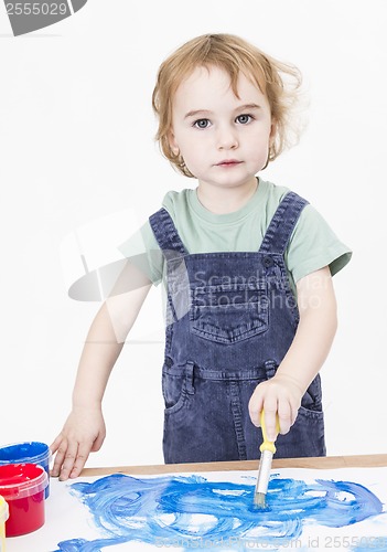 Image of cute girl painting on small desk