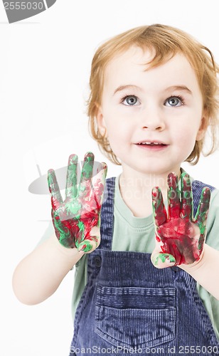 Image of cute little girl with finger paint looking up