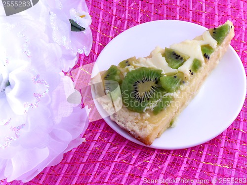 Image of kiwi tasty cake close up at plate with white flowers