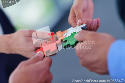 Image of Group of business people assembling jigsaw puzzle