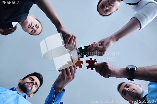 Image of Group of business people assembling jigsaw puzzle