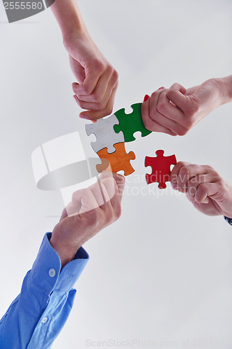 Image of Group of business people assembling jigsaw puzzle