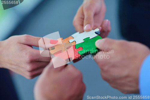 Image of Group of business people assembling jigsaw puzzle