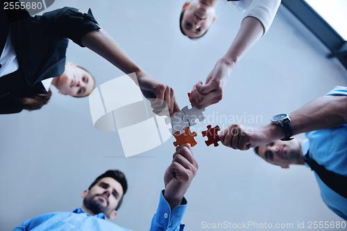 Image of Group of business people assembling jigsaw puzzle