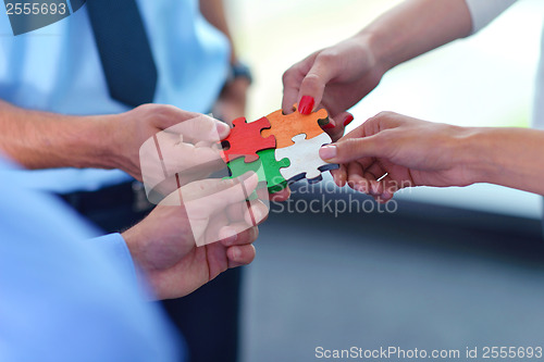 Image of Group of business people assembling jigsaw puzzle