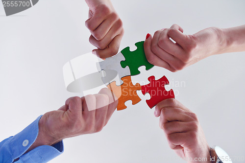 Image of Group of business people assembling jigsaw puzzle