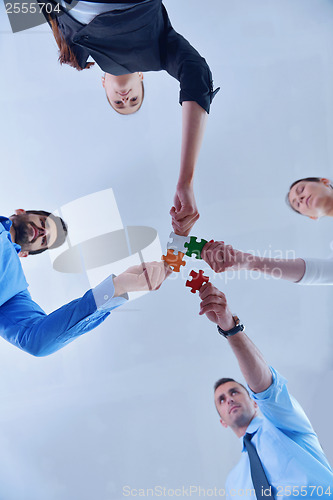 Image of Group of business people assembling jigsaw puzzle