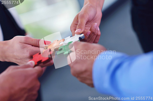 Image of Group of business people assembling jigsaw puzzle