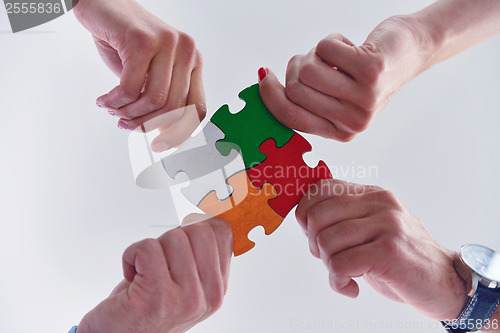 Image of Group of business people assembling jigsaw puzzle