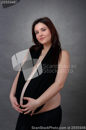 Image of beautiful pregnant young woman tenderly holding her tummy