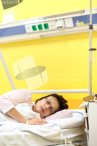 Image of sad middle-aged woman lying in hospital