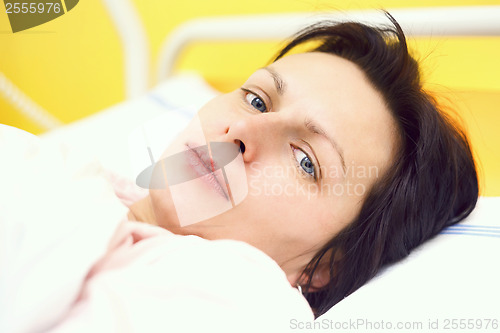 Image of sad middle-aged woman lying in hospital