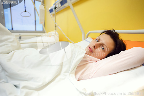 Image of sad middle-aged woman lying in hospital