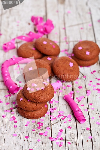 Image of fresh chocolate cookies, coffee beans, pink ribbons and confetti