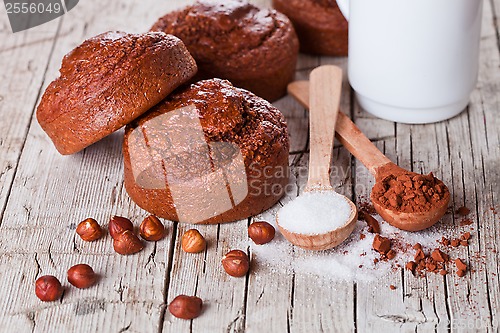 Image of fresh baked browny cakes, milk, sugar, hazelnuts and cocoa powde