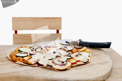 Image of pizza with cutter on small desk