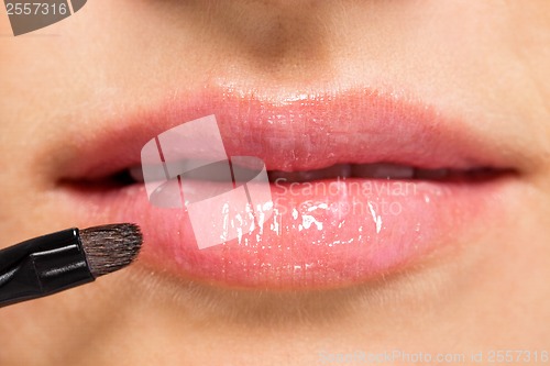 Image of woman applying lipstick on lips natural beauty