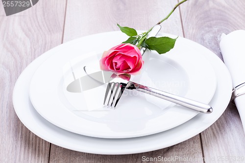 Image of Table setting with a single pink rose