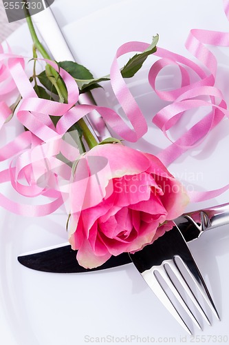 Image of Table setting with a single pink rose