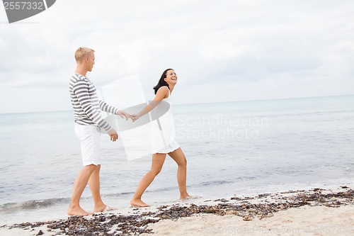 Image of Couple holding hands while walking on the beach