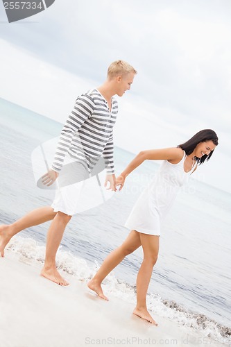 Image of Couple holding hands while walking on the beach