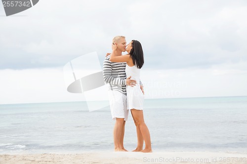 Image of Couple holding hands while walking on the beach