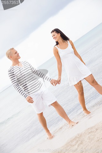 Image of Couple holding hands while walking on the beach