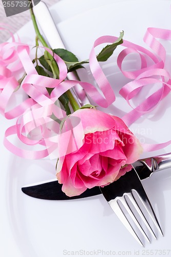 Image of Table setting with a single pink rose