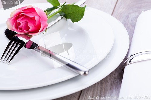 Image of Table setting with a single pink rose