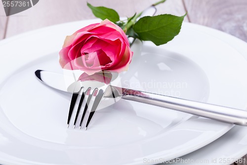 Image of Table setting with a single pink rose